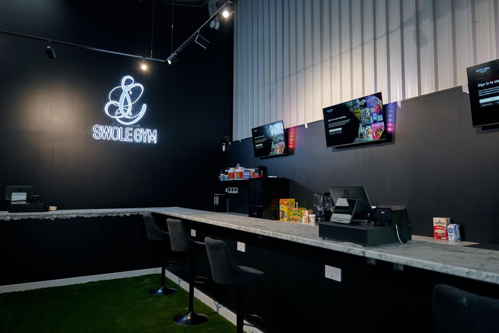 The fuel bar and lounge at Swole Gym under the neon sign